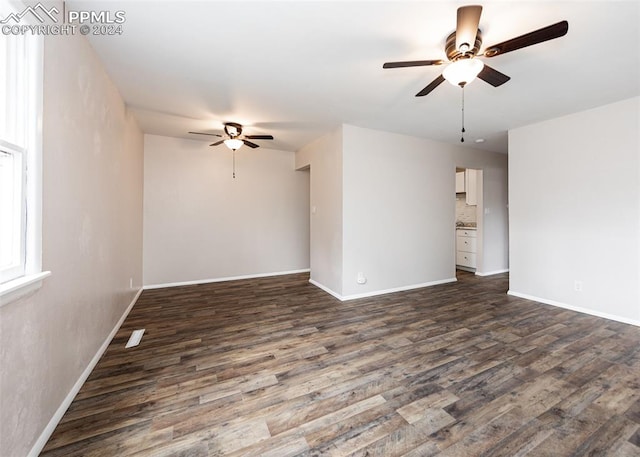 spare room featuring ceiling fan and dark wood-type flooring