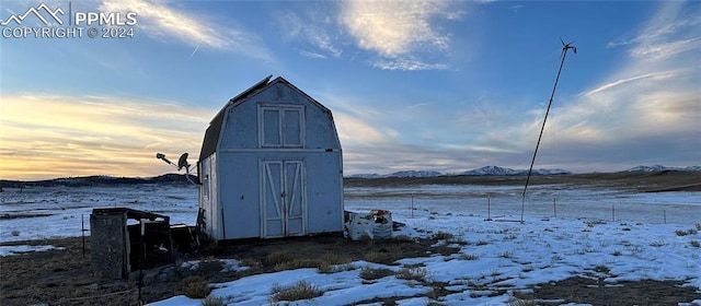 snow covered structure featuring a mountain view