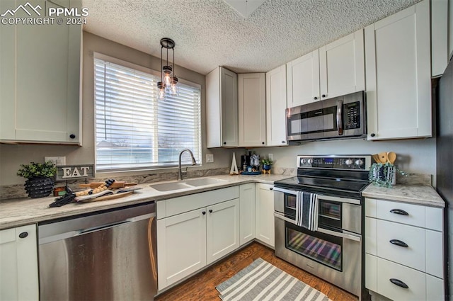 kitchen with sink, a textured ceiling, decorative light fixtures, white cabinetry, and stainless steel appliances