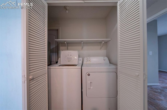 laundry area with hardwood / wood-style floors, a textured ceiling, and separate washer and dryer