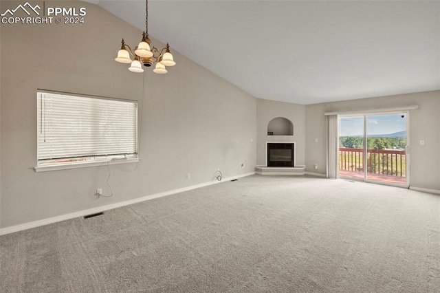 unfurnished living room featuring carpet flooring, vaulted ceiling, and a notable chandelier