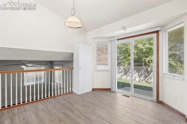 spare room featuring a wealth of natural light, ceiling fan, light hardwood / wood-style floors, and vaulted ceiling