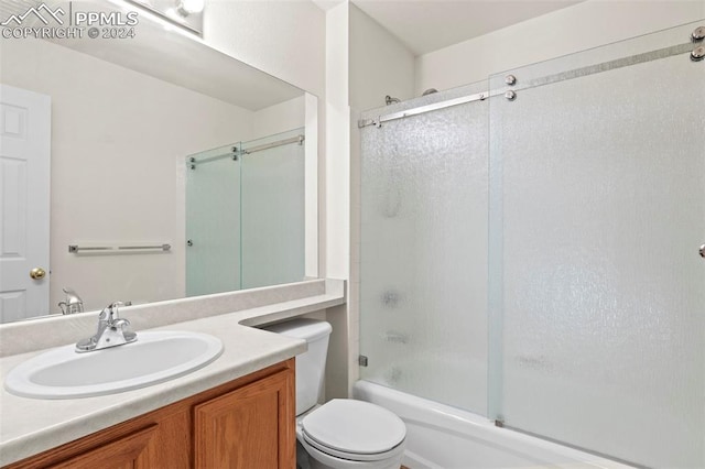 full bathroom with vanity, toilet, and enclosed tub / shower combo