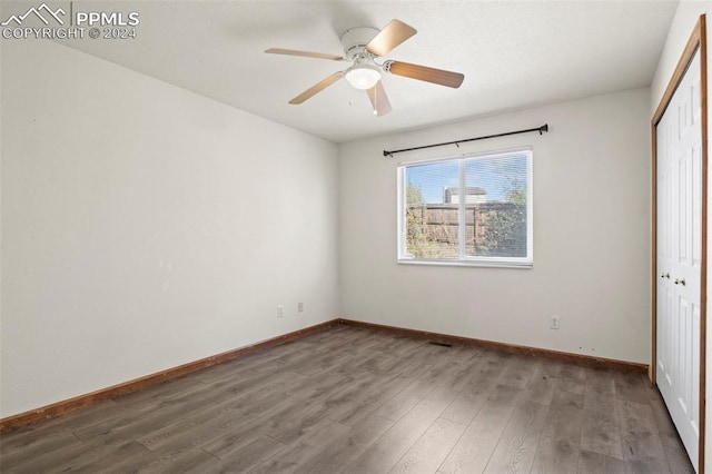 unfurnished bedroom featuring ceiling fan, wood-type flooring, and a closet