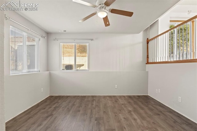 empty room with dark hardwood / wood-style floors and ceiling fan