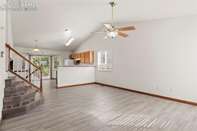 unfurnished living room with light wood-type flooring, ceiling fan, and lofted ceiling