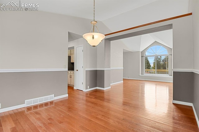 empty room with light hardwood / wood-style flooring and lofted ceiling