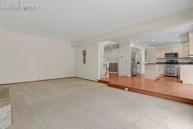 unfurnished living room featuring light colored carpet