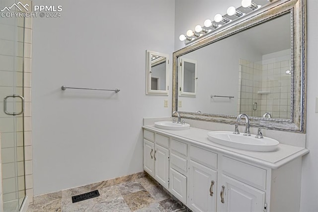 bathroom featuring a shower with door and vanity