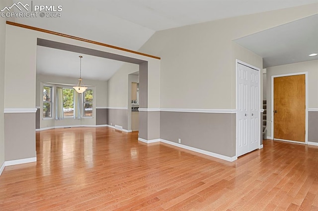 spare room featuring hardwood / wood-style floors and lofted ceiling