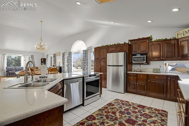 kitchen featuring sink, light tile patterned floors, hanging light fixtures, stainless steel appliances, and vaulted ceiling