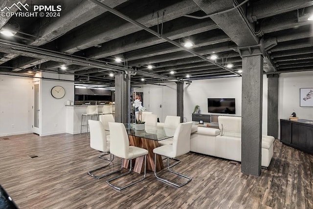 dining area with dark wood-type flooring and indoor bar