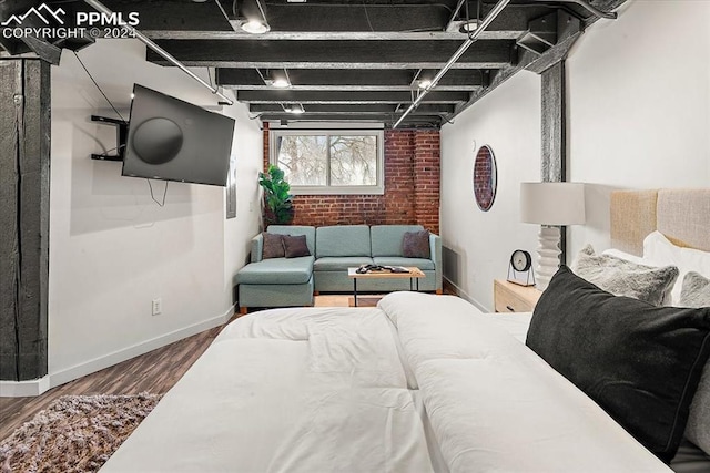 interior space with hardwood / wood-style floors and brick wall