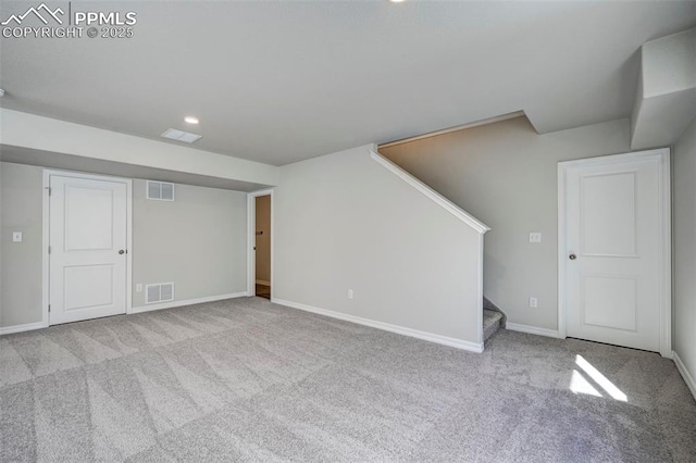 interior space featuring light colored carpet, visible vents, and stairway