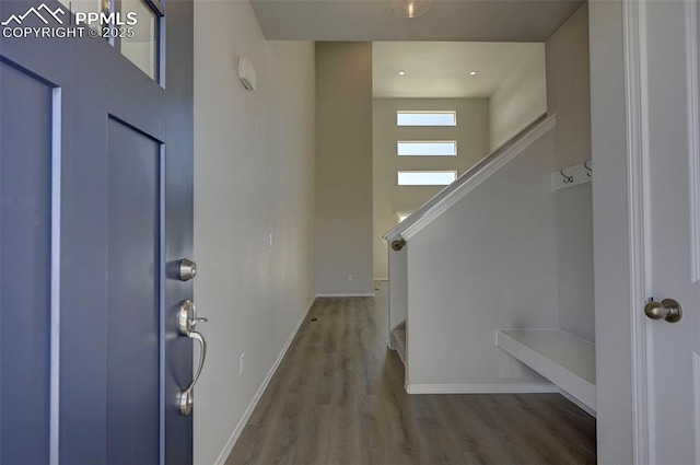 foyer with stairway, wood finished floors, and baseboards