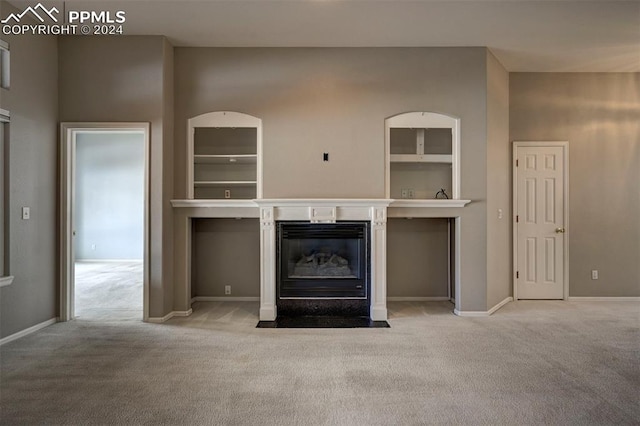 unfurnished living room featuring light colored carpet and built in features