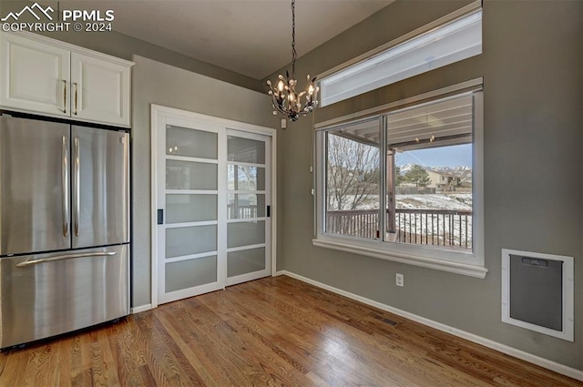 unfurnished dining area featuring a chandelier and light hardwood / wood-style floors