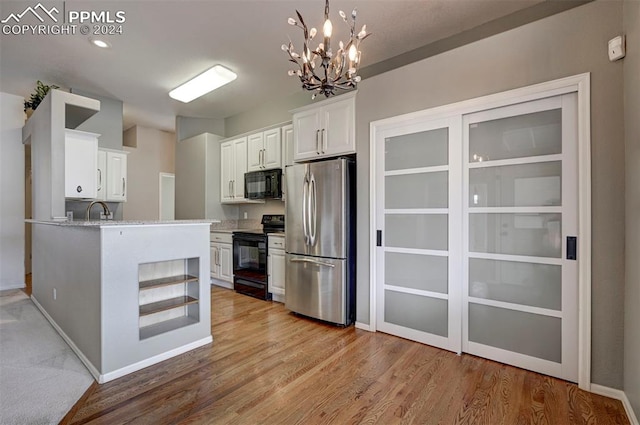 kitchen featuring black appliances, a notable chandelier, light wood-type flooring, and white cabinetry