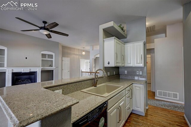 kitchen with kitchen peninsula, sink, hardwood / wood-style flooring, white cabinets, and black dishwasher