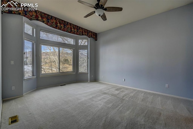 carpeted empty room featuring ceiling fan