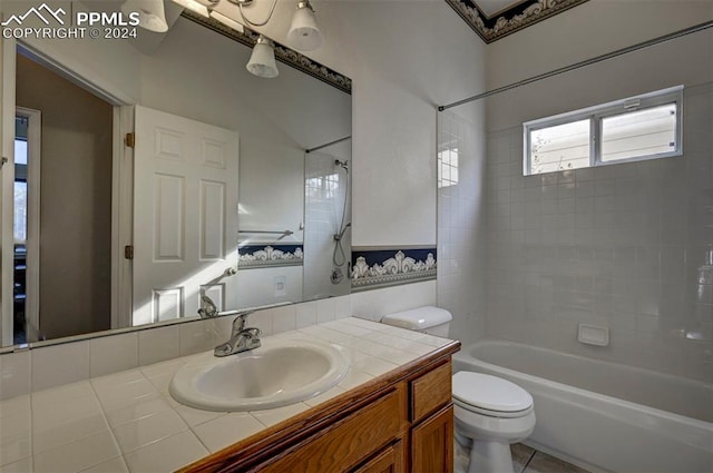 full bathroom with vanity, tiled shower / bath combo, toilet, and tile patterned flooring