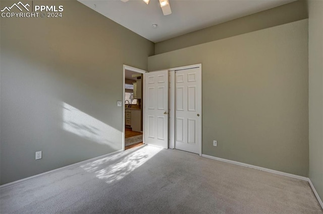 carpeted spare room with ceiling fan