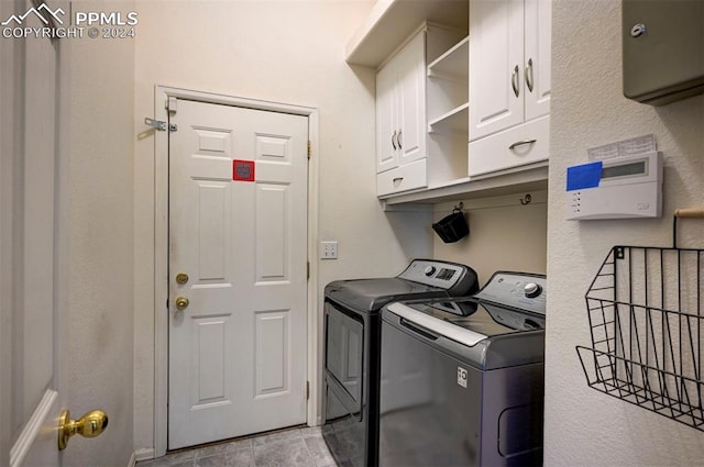 laundry area with cabinets and washing machine and clothes dryer