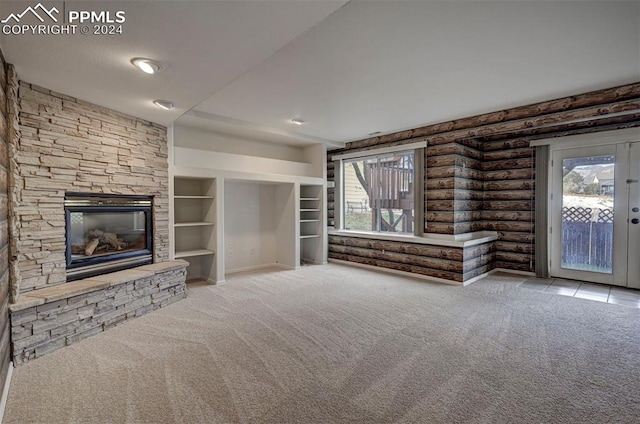 unfurnished living room featuring a stone fireplace, light carpet, and a healthy amount of sunlight