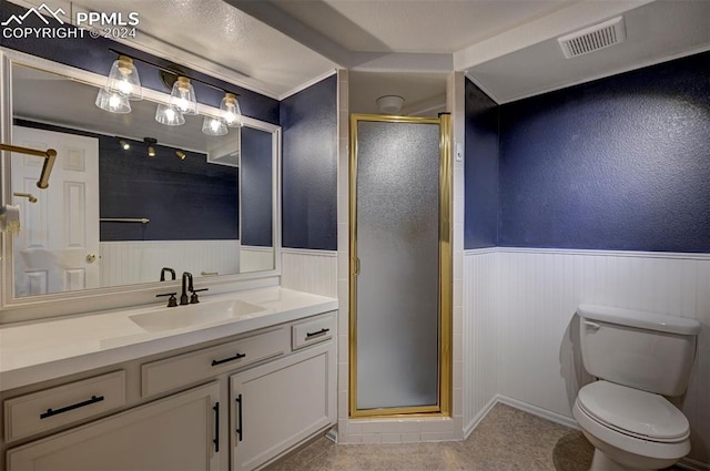 bathroom featuring vanity, a shower with shower door, and toilet