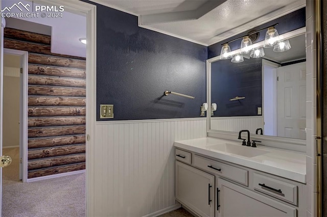 bathroom featuring rustic walls, vanity, and a textured ceiling