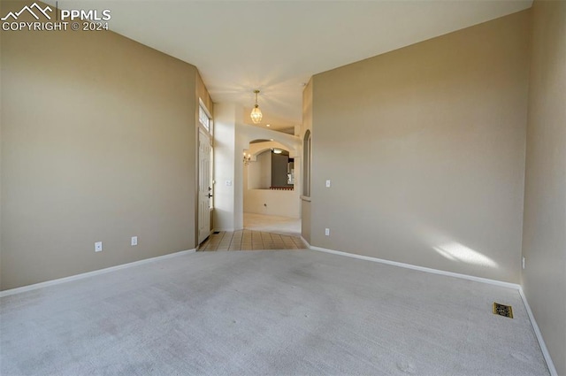 unfurnished room featuring light carpet