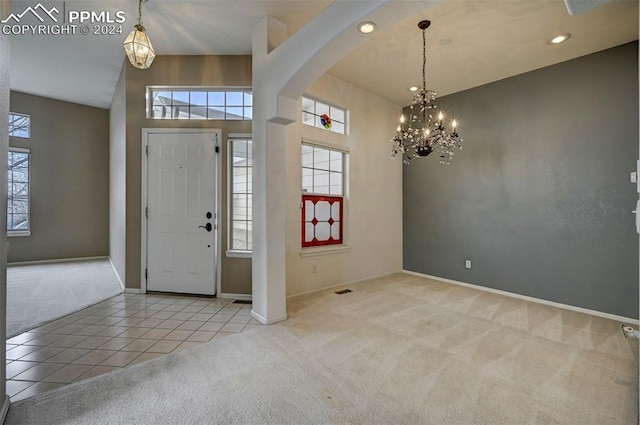 entrance foyer with light carpet and a chandelier