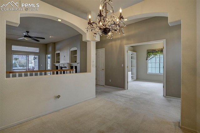 interior space featuring ceiling fan with notable chandelier