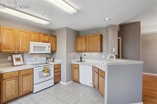 kitchen featuring light hardwood / wood-style floors, sink, white appliances, and kitchen peninsula