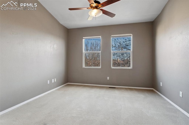 carpeted spare room featuring ceiling fan