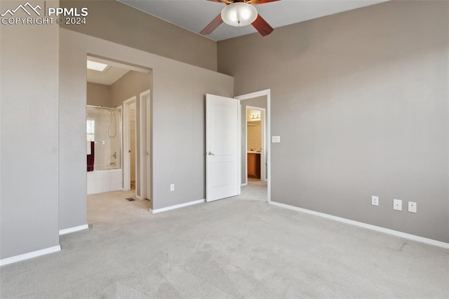 unfurnished bedroom featuring ensuite bath, light carpet, and ceiling fan