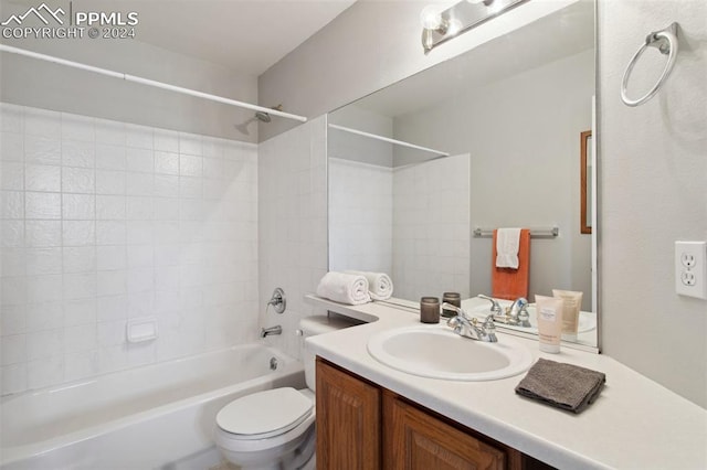 full bathroom with vanity, tiled shower / bath combo, and toilet