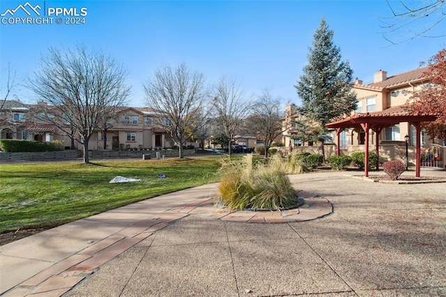 view of home's community with a pergola and a lawn