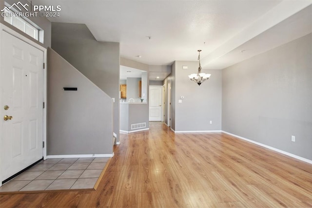 entrance foyer with light hardwood / wood-style floors and an inviting chandelier