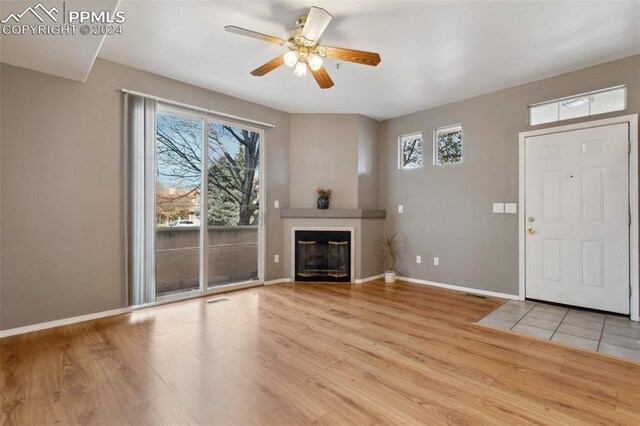 unfurnished living room with light hardwood / wood-style flooring, plenty of natural light, and ceiling fan