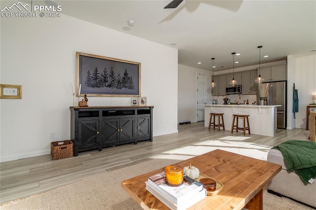 living room with ceiling fan and light wood-type flooring