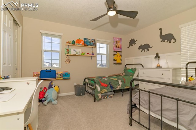 carpeted bedroom with ceiling fan, a closet, and multiple windows