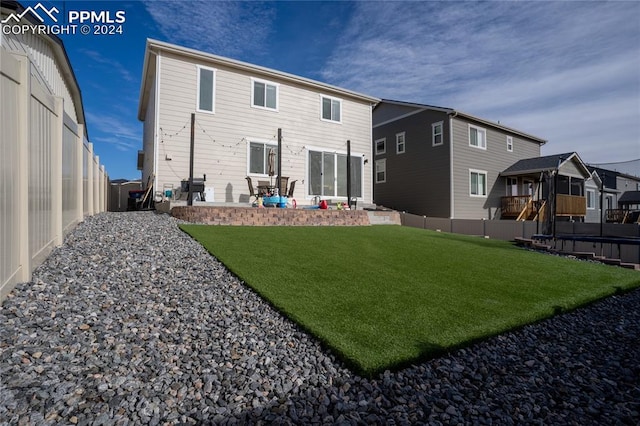 rear view of property with a yard and a patio