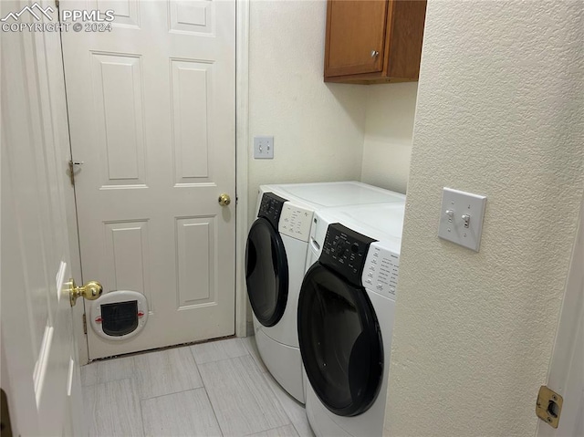 washroom with cabinets and washing machine and dryer