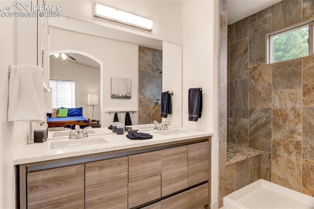 bathroom featuring a tile shower, ceiling fan, and vanity