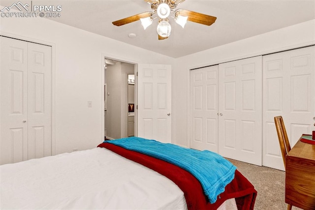 carpeted bedroom featuring ceiling fan and multiple closets