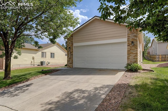 ranch-style house with a garage, central air condition unit, and a front yard