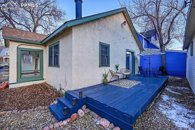 snow covered property with a wooden deck