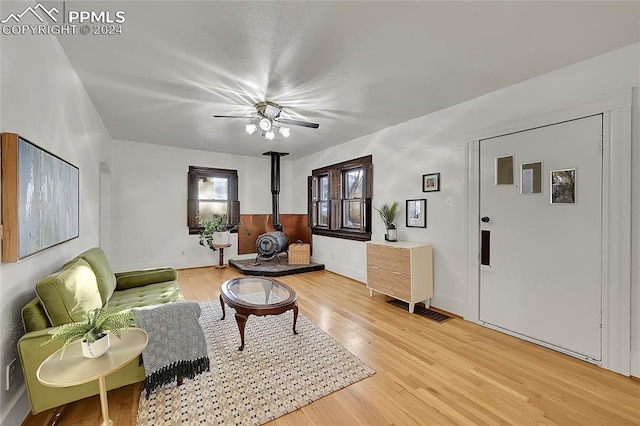 3 S 8th St, Colorado Springs, CO 80905 - living area featuring a wood stove, light wood-type flooring, a ceiling fan, and baseboards