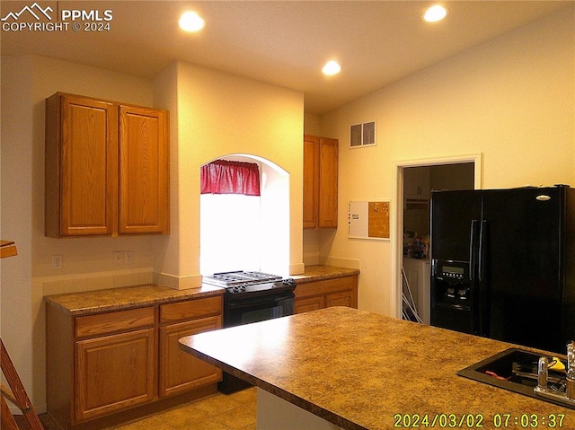 kitchen with vaulted ceiling and black appliances